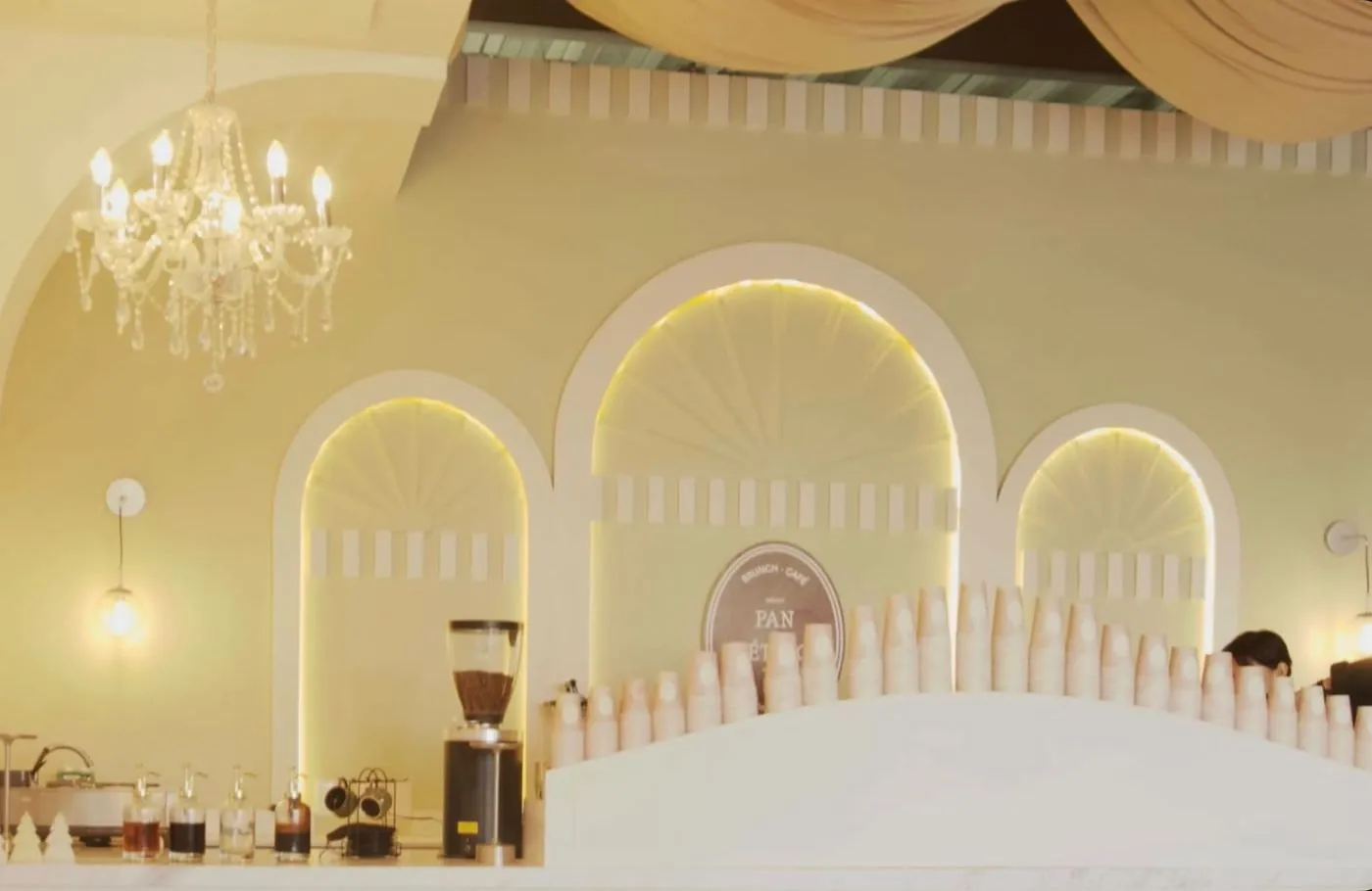 Barra de café con arcos iluminados y candil de cristal